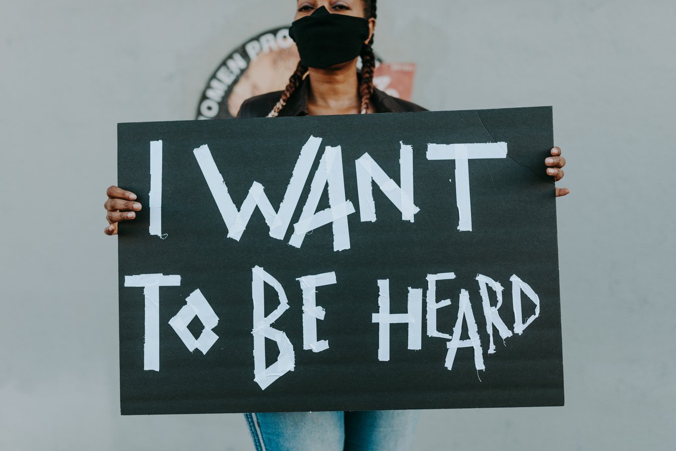 Woman with Face Mask Holding a Sign